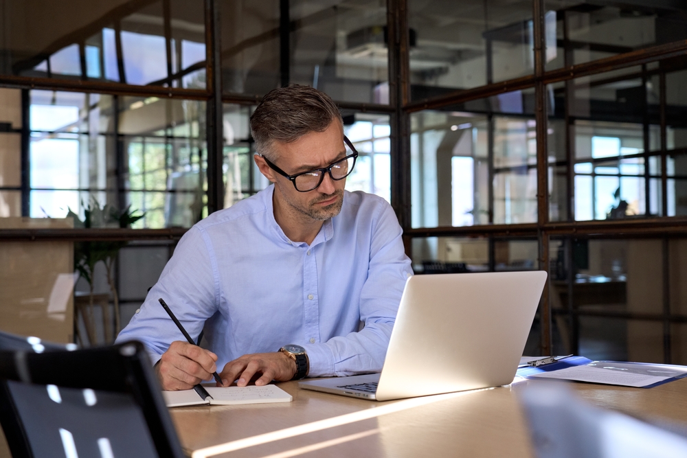 Business Man with Glasses Looking at his Laptop